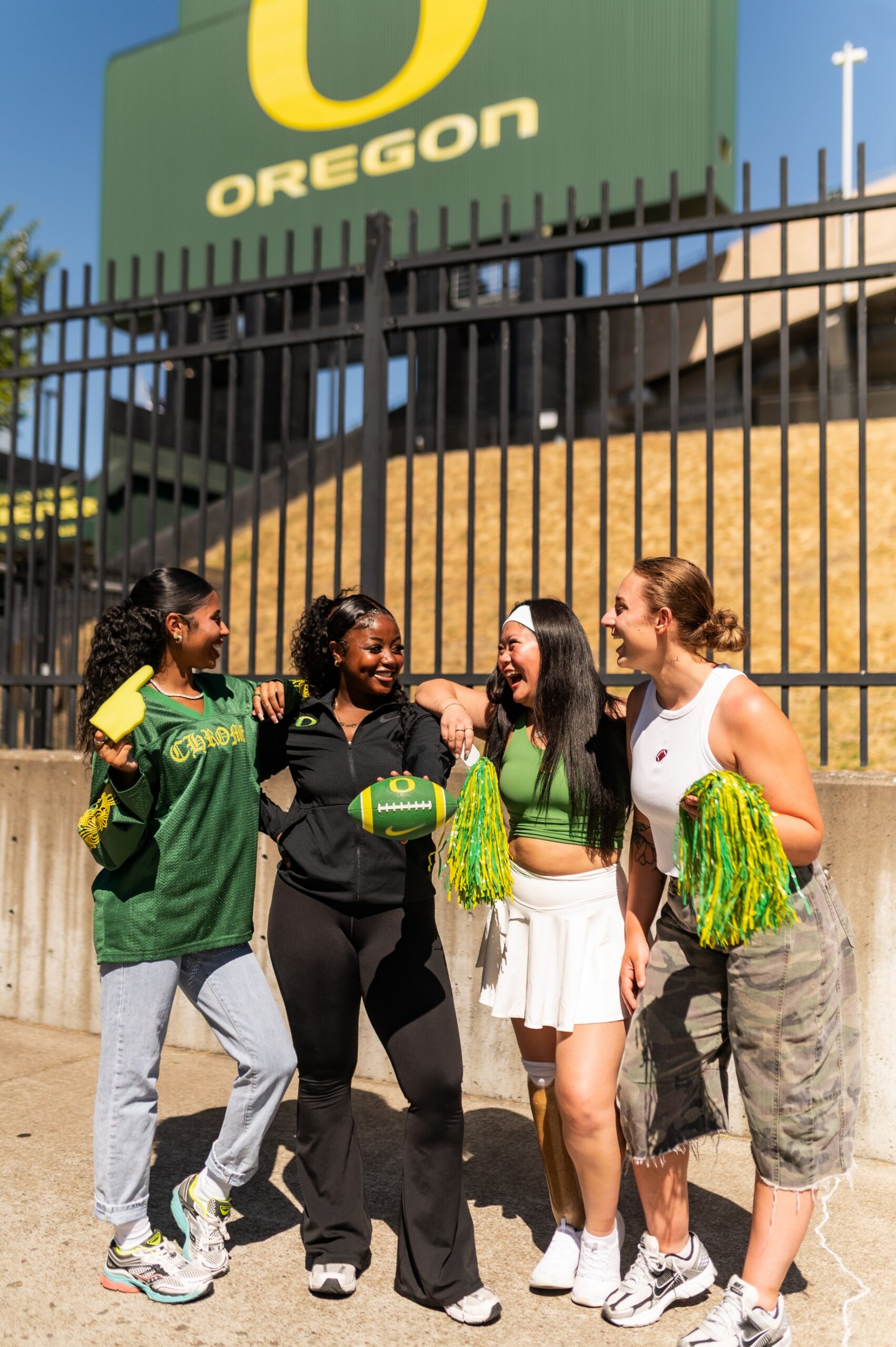 Four friends in their Oregon Duck gear outside Autzen stadium