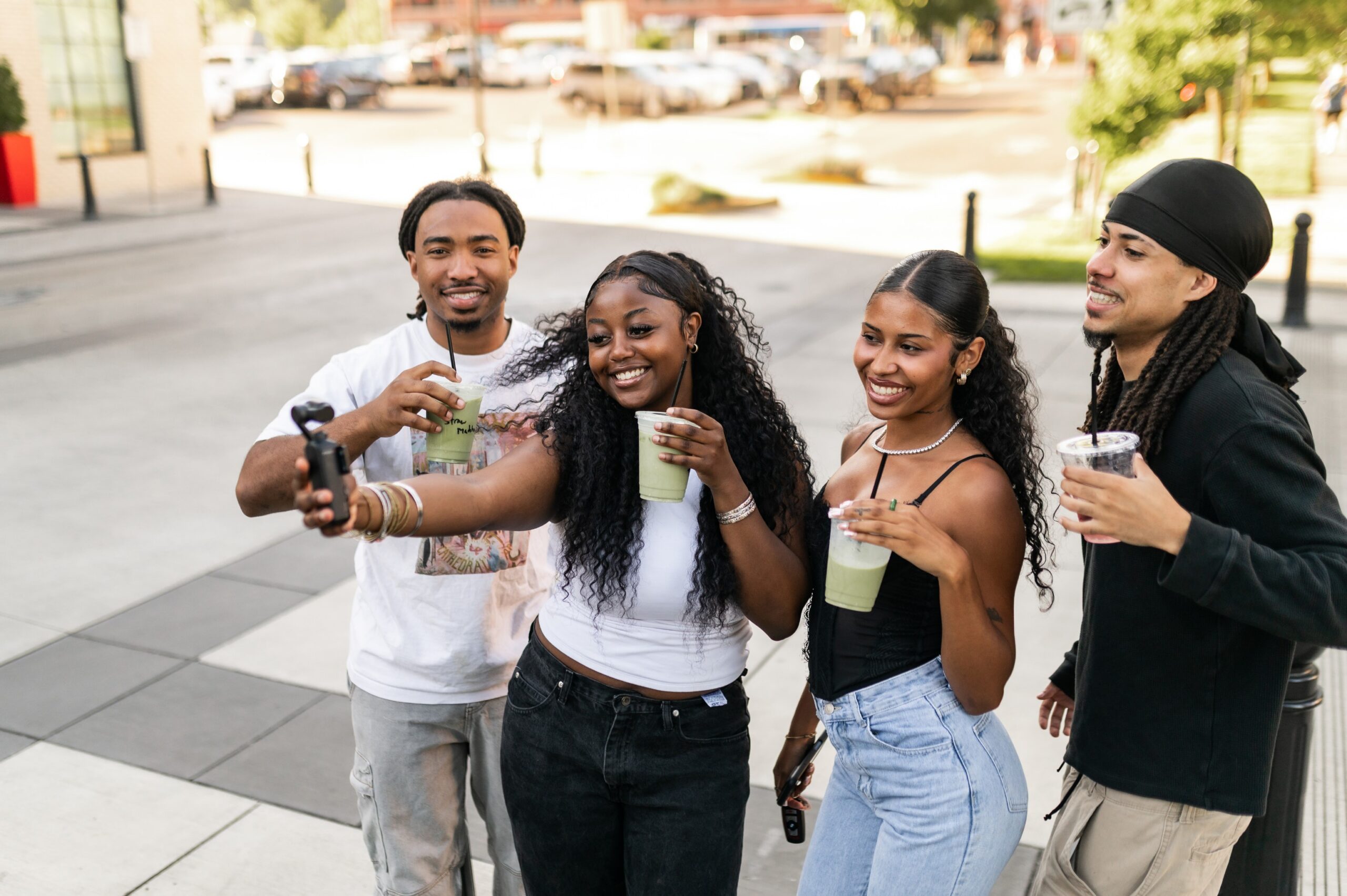 Four friends taking a selfie with their iced matchas