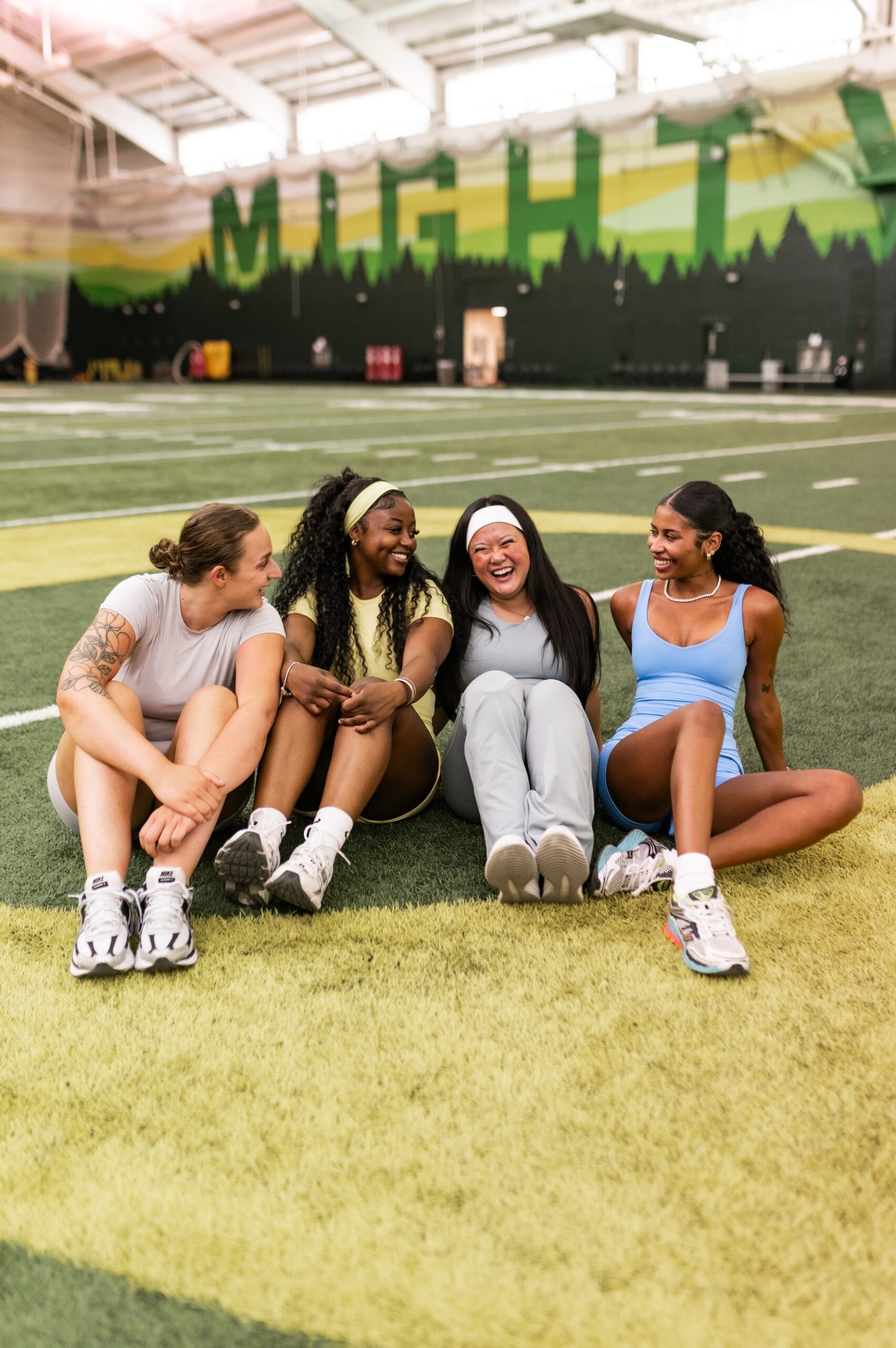 Four girls launching on the University of Oregon practice football field
