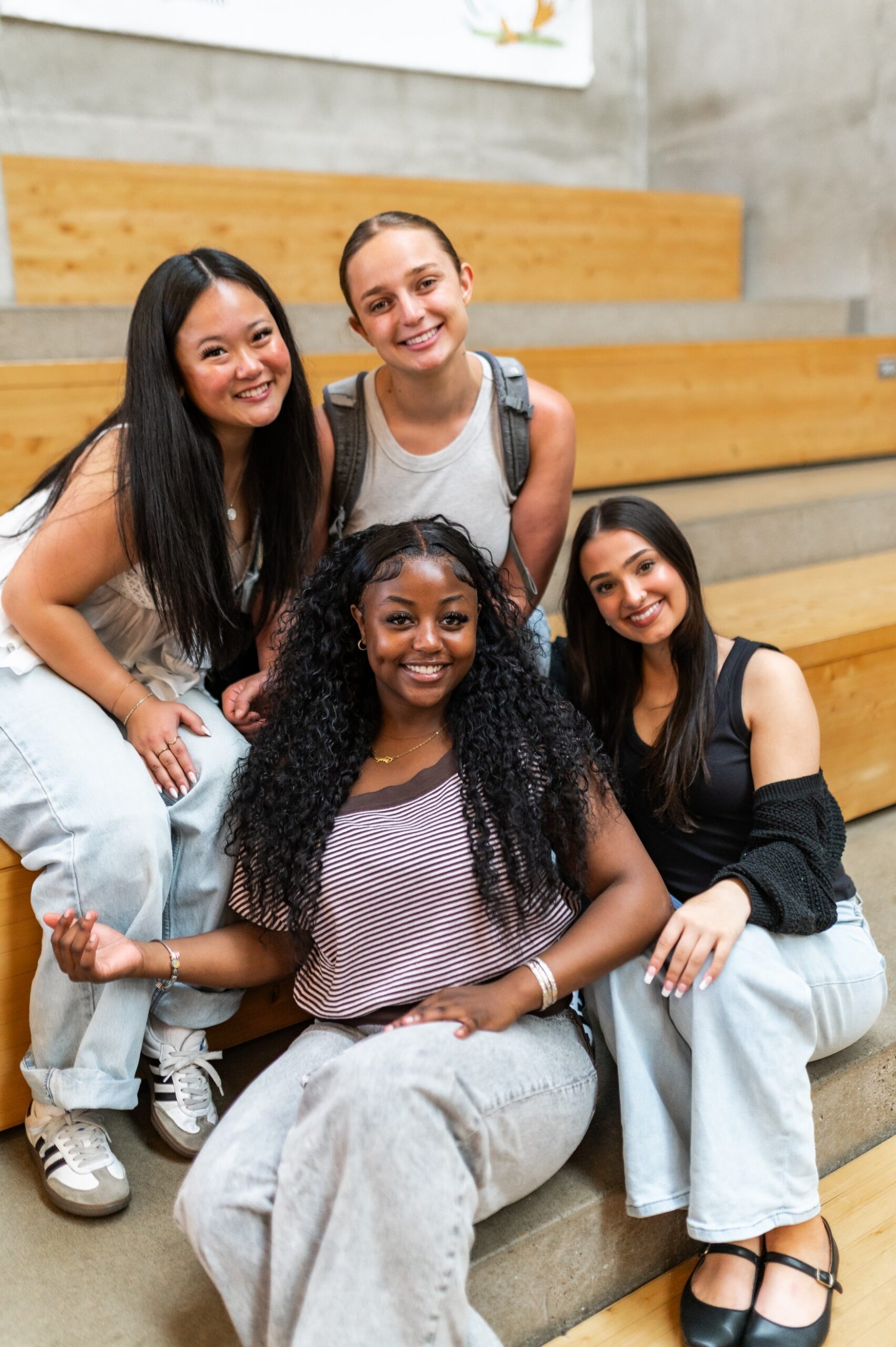 Four girls smile for a photo on the steps in the EMU