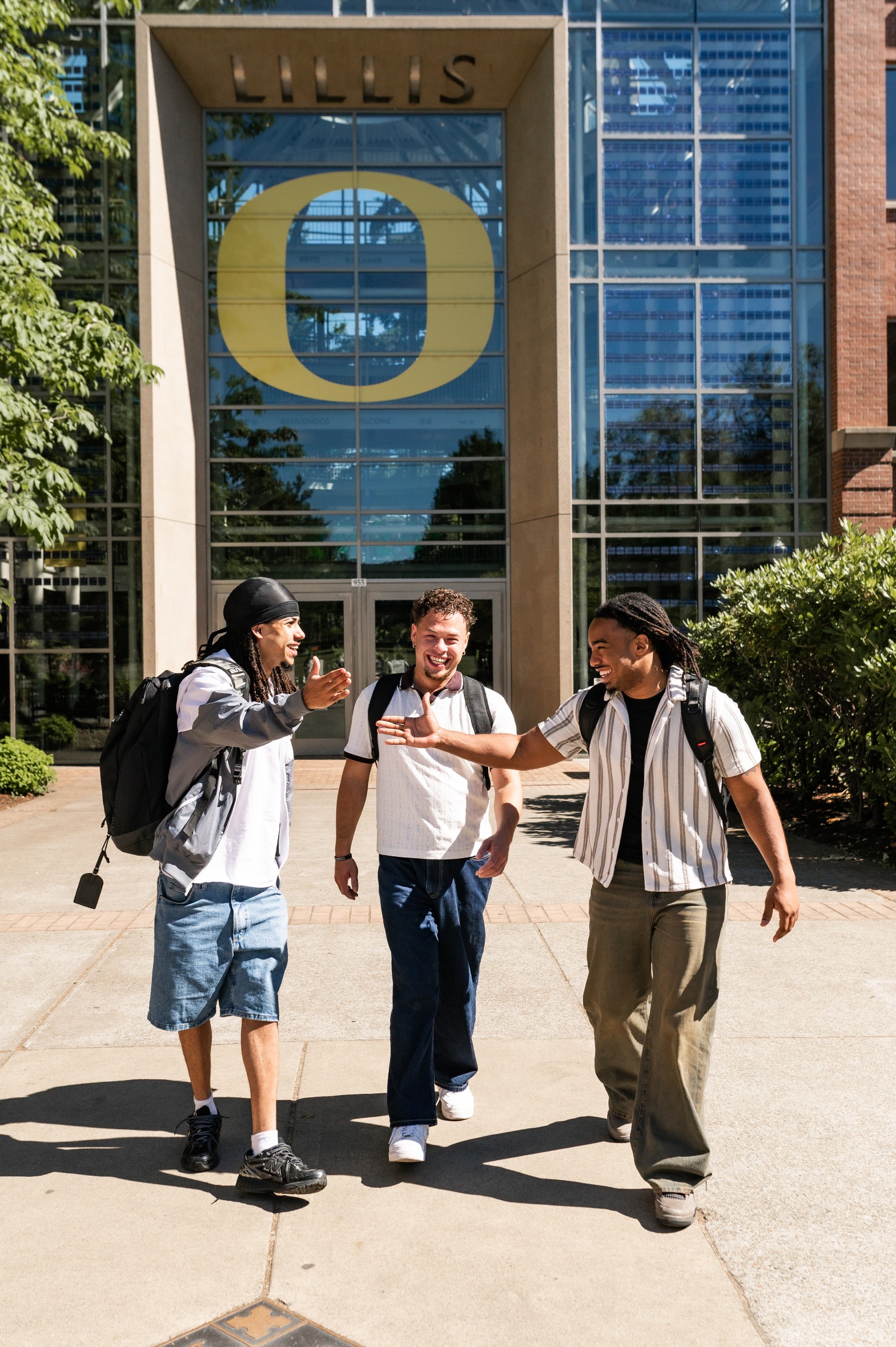 Friends greeting each other in front of the Lillis Business Complex