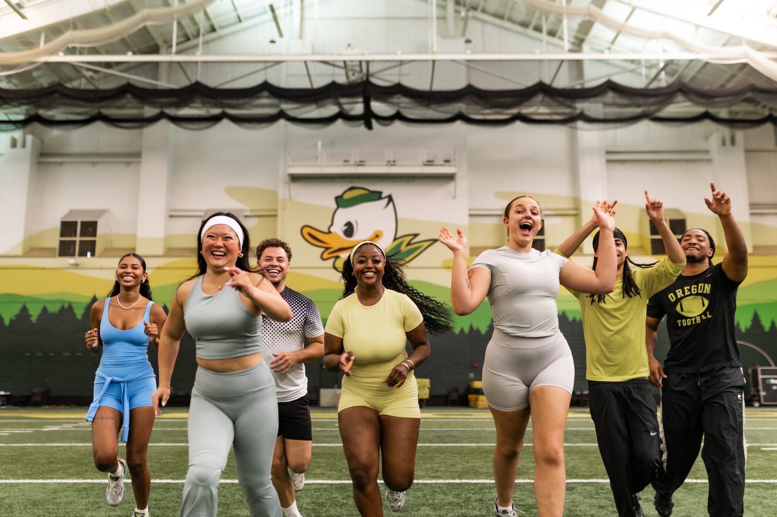 Group of students running on the Oregon Football practice field