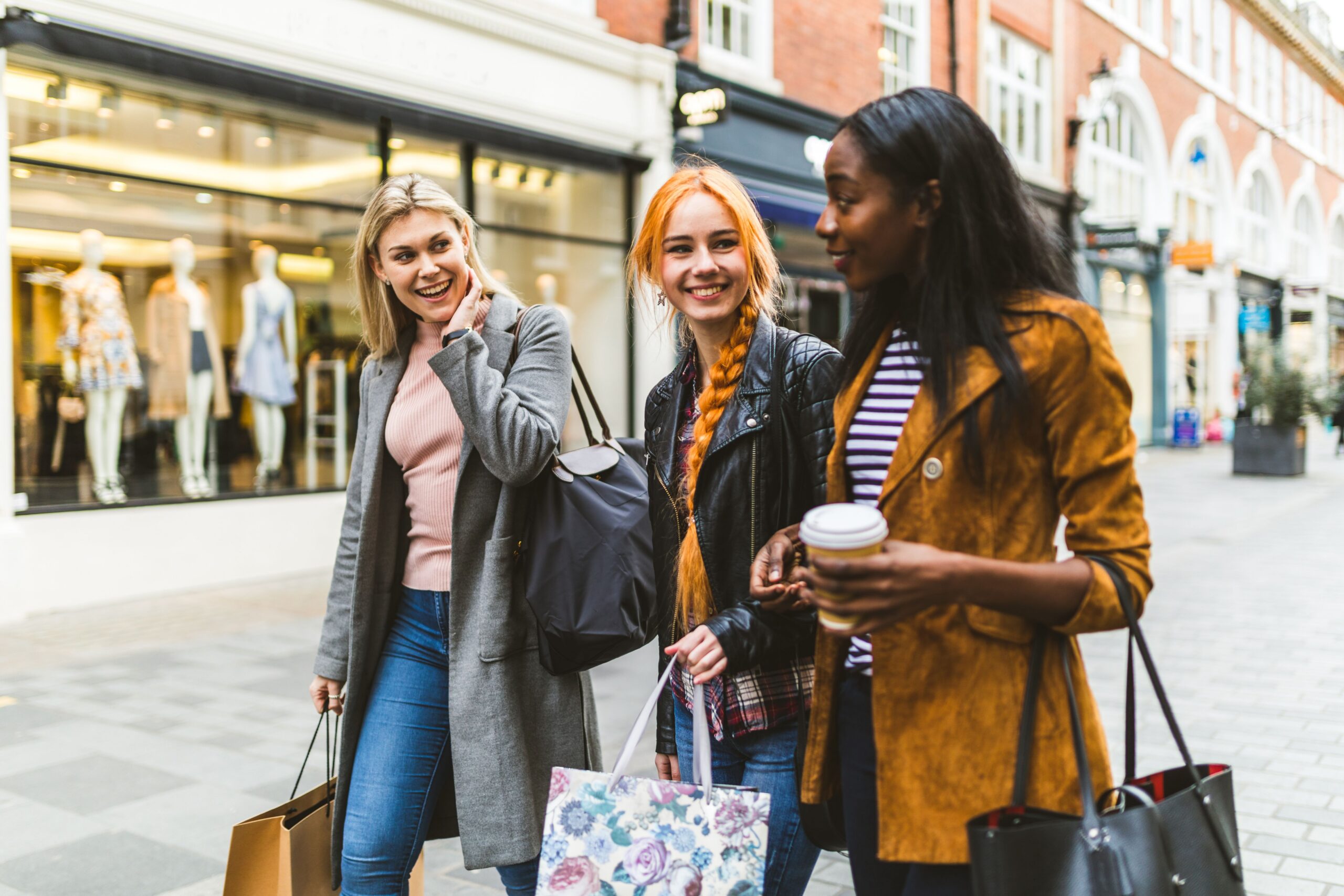 friends strolling past urban shops scaled
